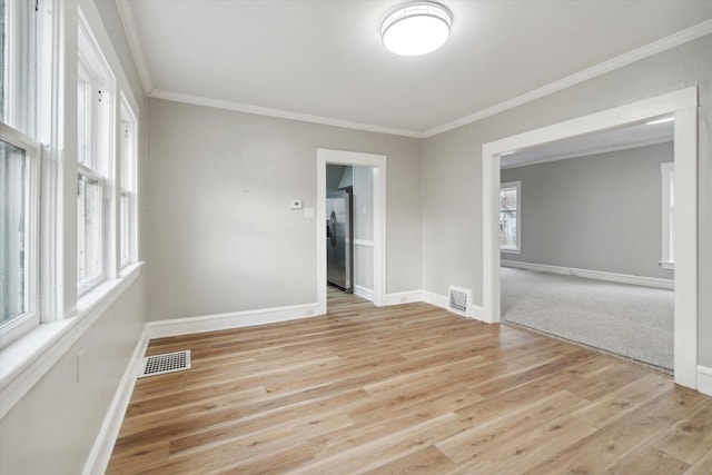 unfurnished room featuring light hardwood / wood-style flooring and crown molding