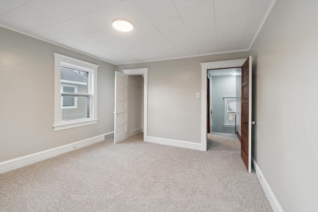 unfurnished bedroom with ornamental molding and light carpet