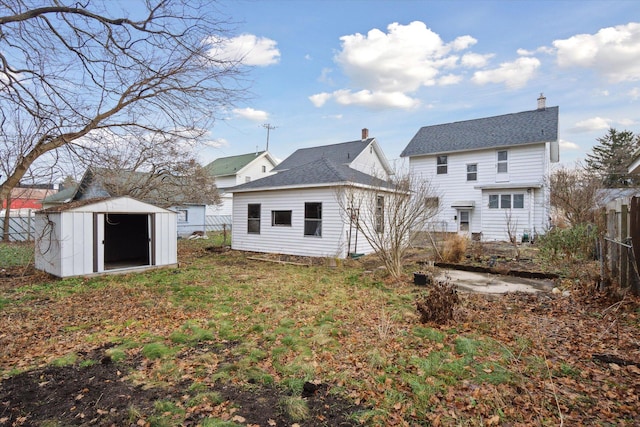 rear view of property featuring a storage unit