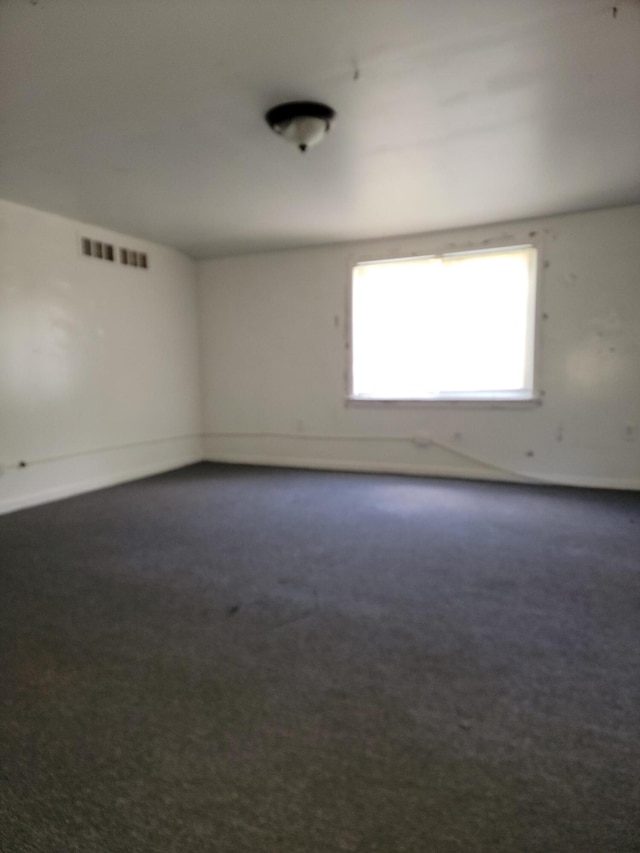 empty room featuring dark colored carpet