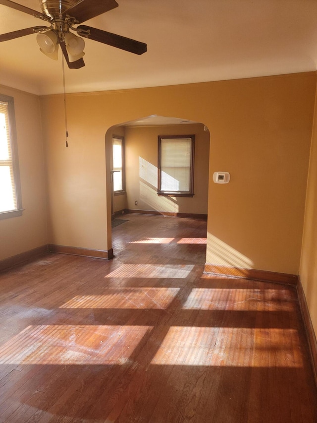 empty room with ceiling fan and dark wood-type flooring