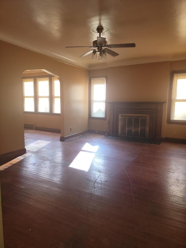 unfurnished living room featuring dark hardwood / wood-style floors and ceiling fan