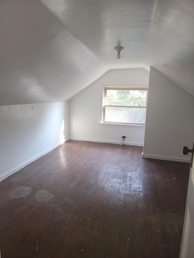 bonus room with dark hardwood / wood-style flooring and vaulted ceiling