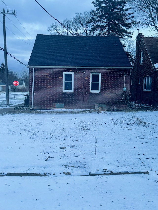 view of snow covered back of property