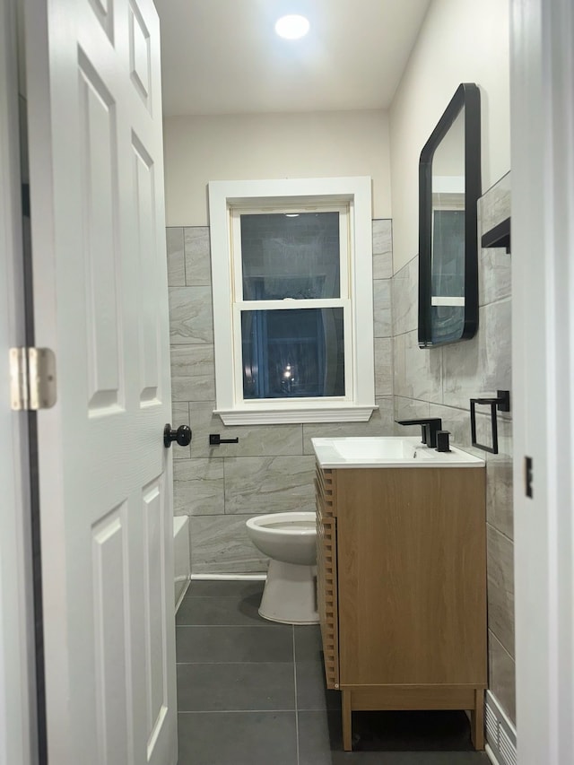 bathroom with tile patterned flooring, vanity, tile walls, and toilet