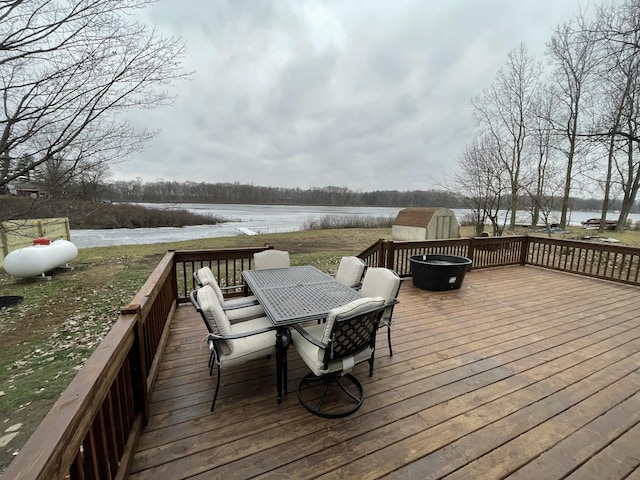 deck with a water view and a storage shed