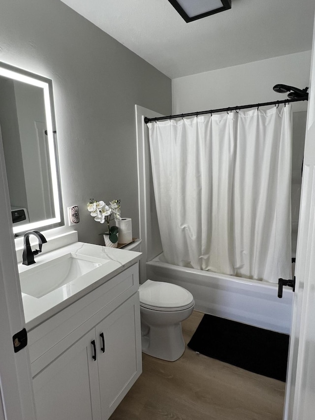 full bathroom featuring hardwood / wood-style floors, vanity, shower / bath combination with curtain, and toilet