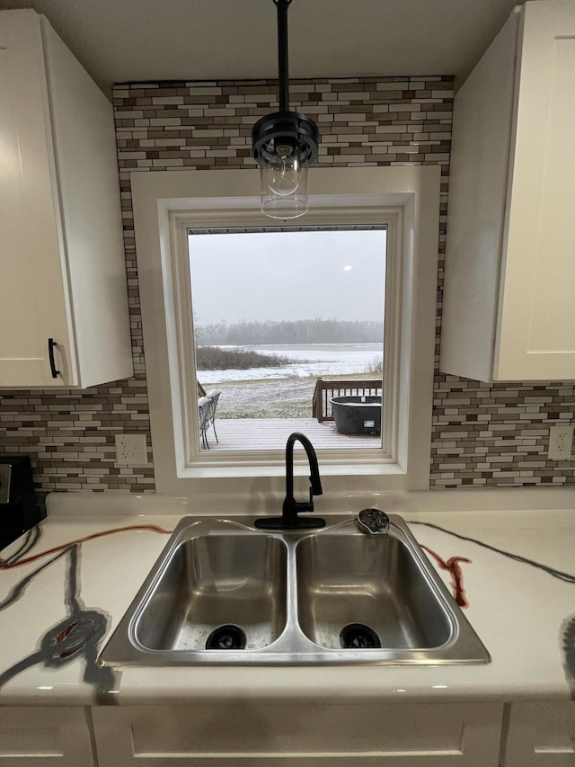 kitchen featuring decorative backsplash, sink, and white cabinets