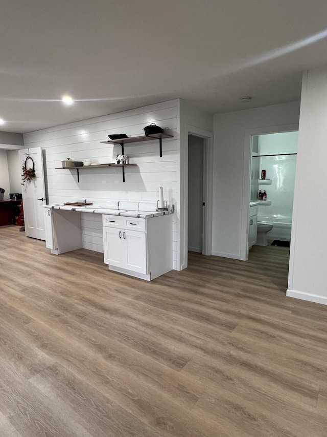 kitchen featuring light hardwood / wood-style flooring, white cabinets, and sink