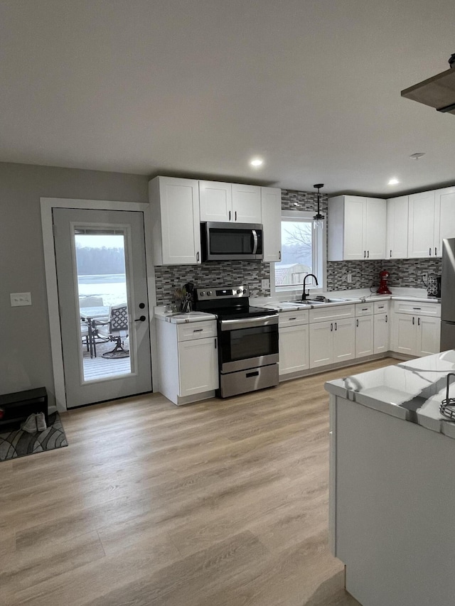 kitchen featuring light hardwood / wood-style flooring, white cabinets, and appliances with stainless steel finishes