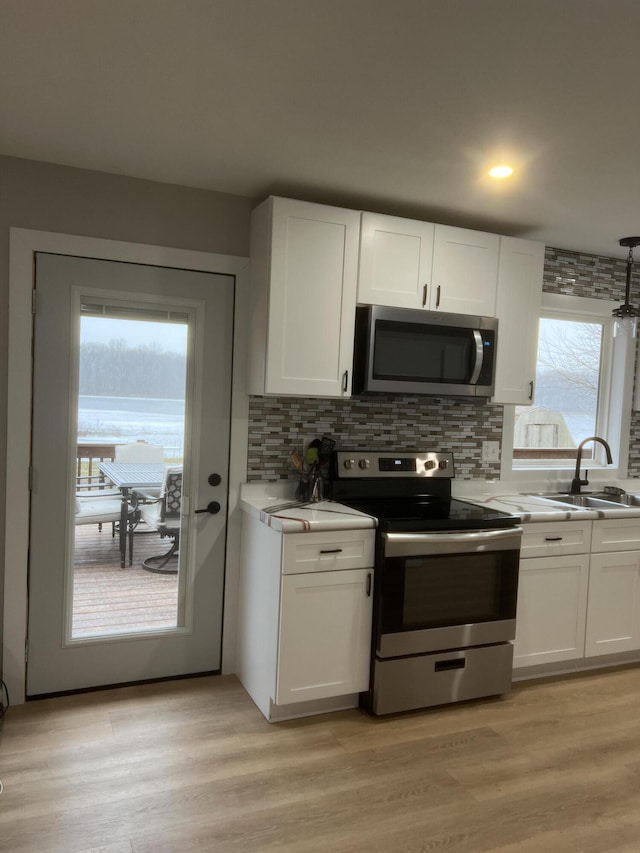 kitchen featuring sink, white cabinets, plenty of natural light, and appliances with stainless steel finishes