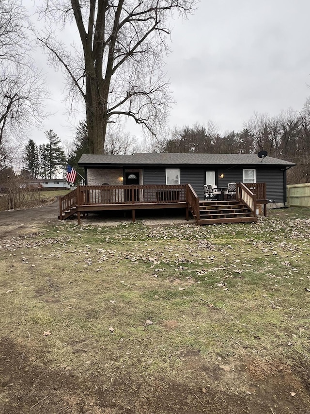 back of property with a yard and a wooden deck