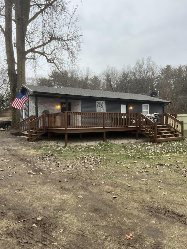 rear view of property featuring a wooden deck