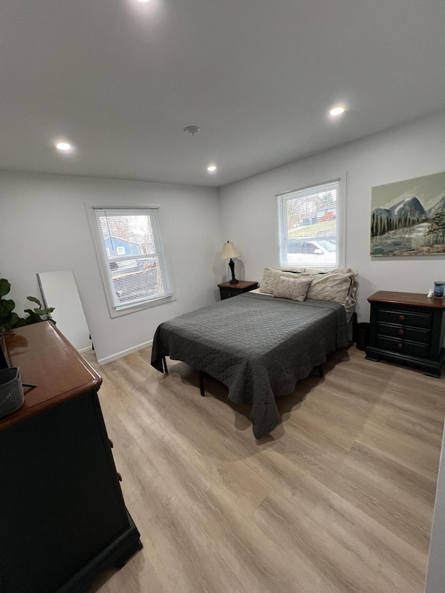 bedroom with light wood-type flooring and multiple windows