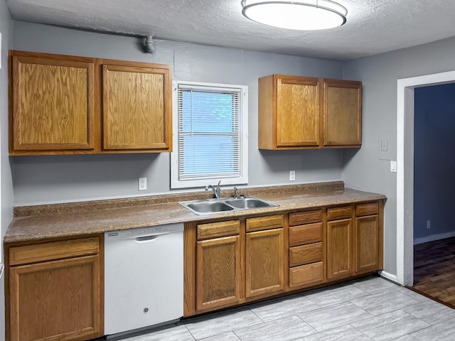 kitchen with sink, white dishwasher, a textured ceiling, and light hardwood / wood-style flooring