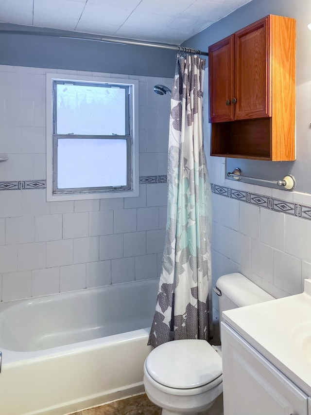 full bathroom featuring shower / tub combo, vanity, toilet, and tile walls