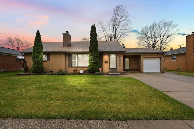 single story home featuring a lawn and a garage