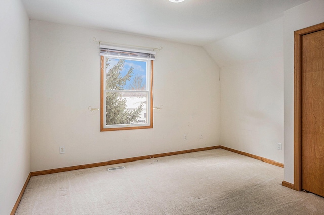 additional living space with light colored carpet and vaulted ceiling