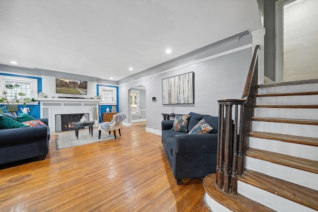 living room featuring wood-type flooring and a brick fireplace