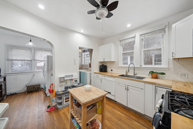 kitchen with washer / clothes dryer, sink, white cabinets, and white appliances