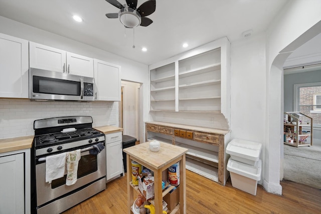 kitchen featuring stainless steel appliances, butcher block countertops, and white cabinetry