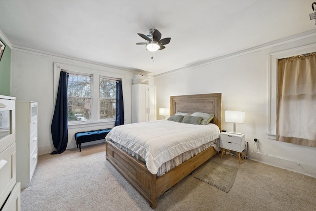 carpeted bedroom with ceiling fan and ornamental molding