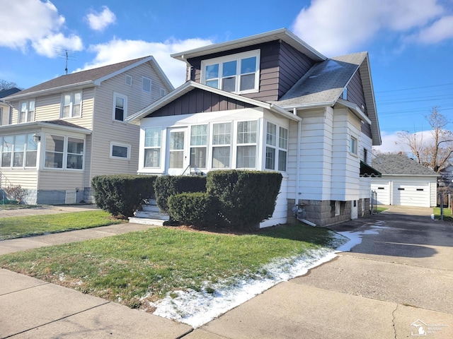 view of front of property featuring a front yard, a garage, and an outdoor structure