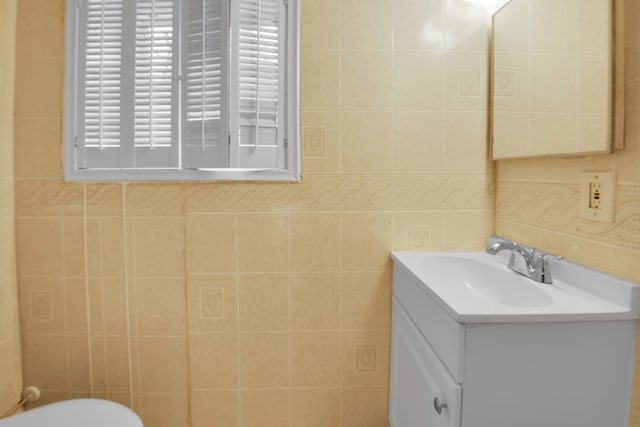 bathroom featuring vanity and tile walls