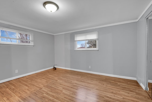 empty room featuring crown molding and light hardwood / wood-style flooring