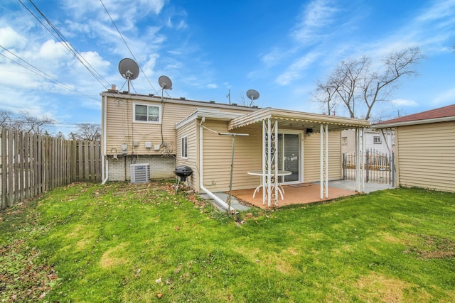 back of property with a lawn, central air condition unit, and a patio