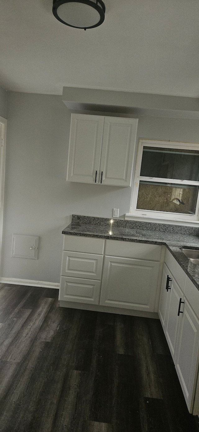 kitchen featuring sink, white cabinetry, and dark wood-type flooring