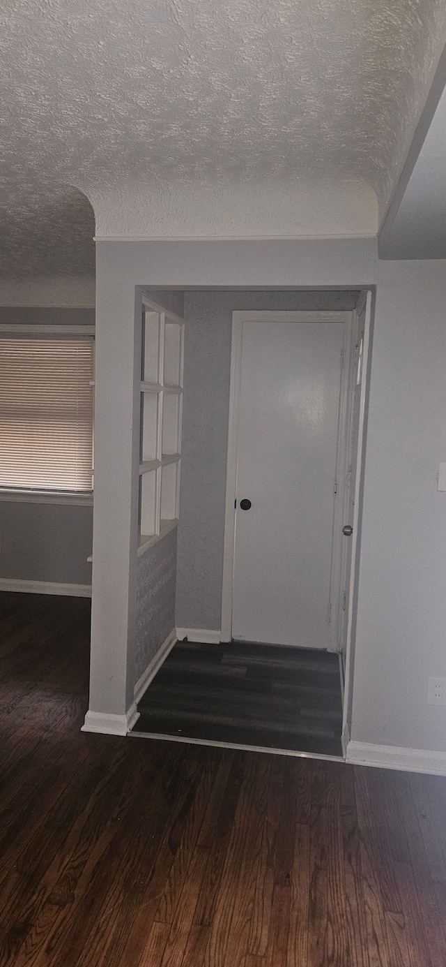 entrance foyer with a textured ceiling and dark hardwood / wood-style floors