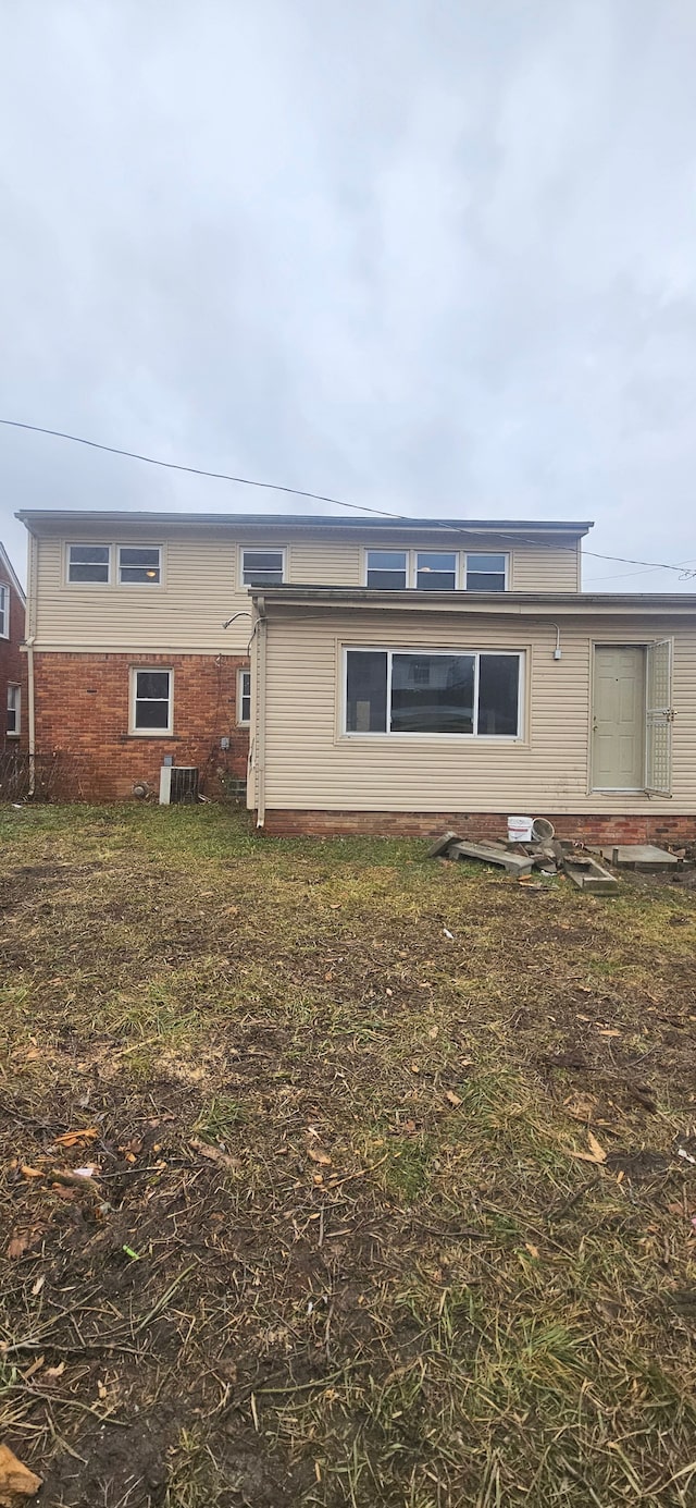 back of house with entry steps, central AC unit, and brick siding