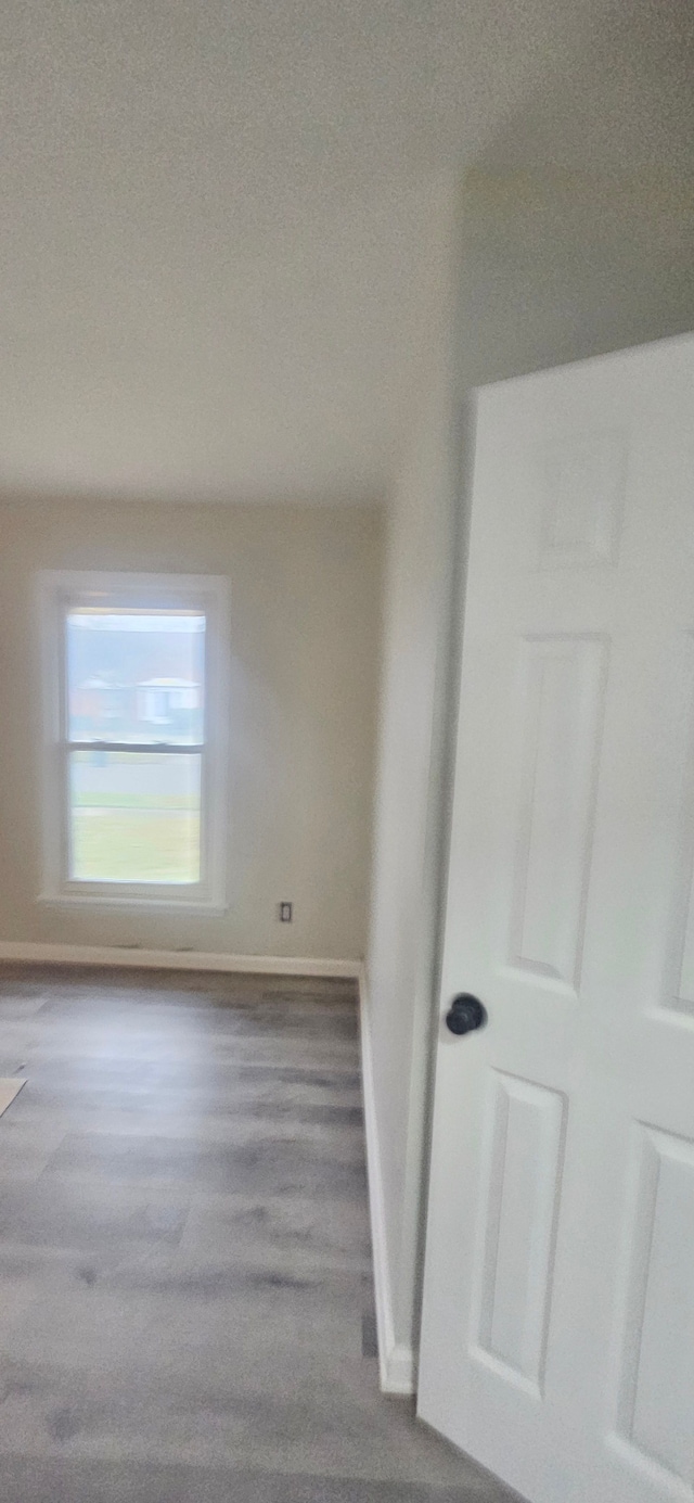 spare room with wood finished floors and baseboards