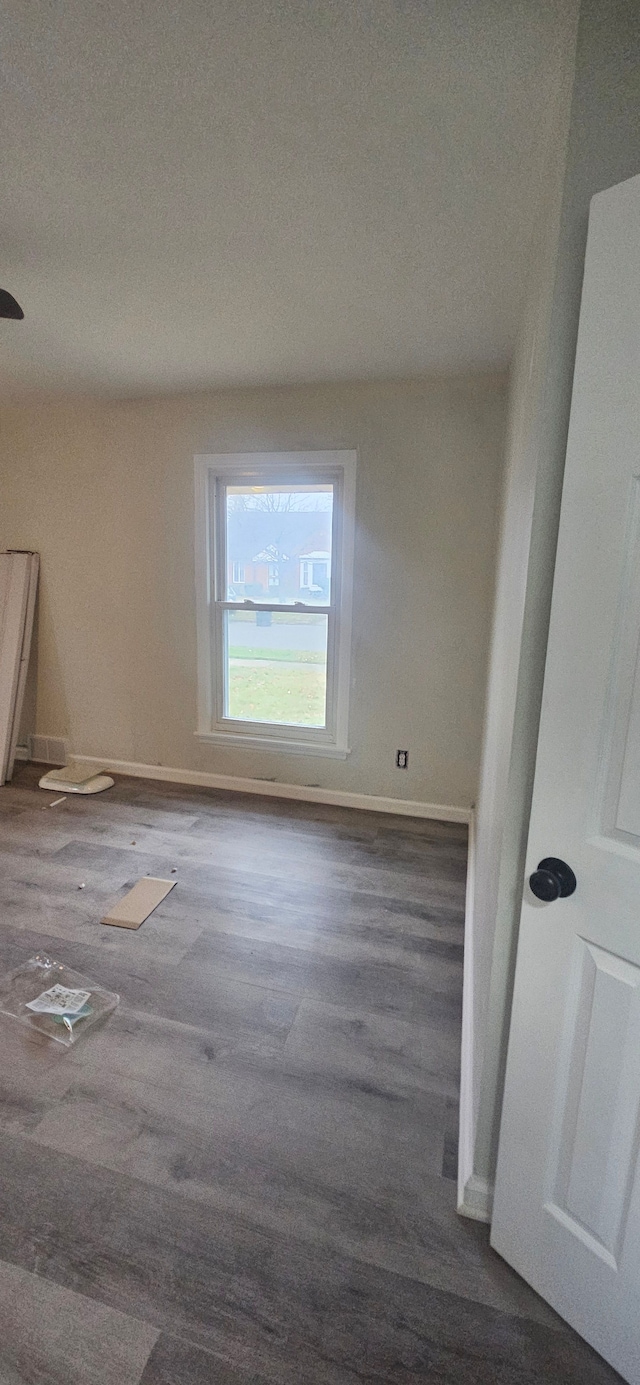 spare room featuring dark wood-type flooring and a textured ceiling