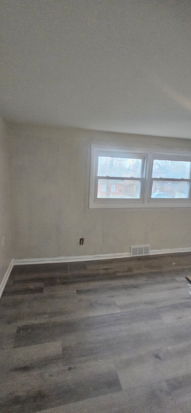 empty room with a textured ceiling and dark hardwood / wood-style floors