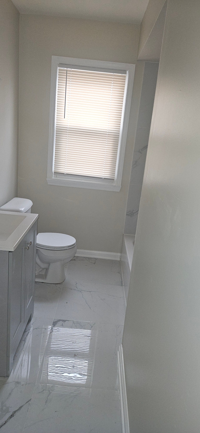 full bathroom with marble finish floor, baseboards, vanity, and toilet