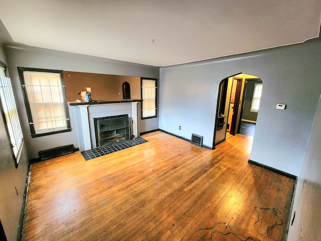 unfurnished living room with light hardwood / wood-style floors and a tile fireplace