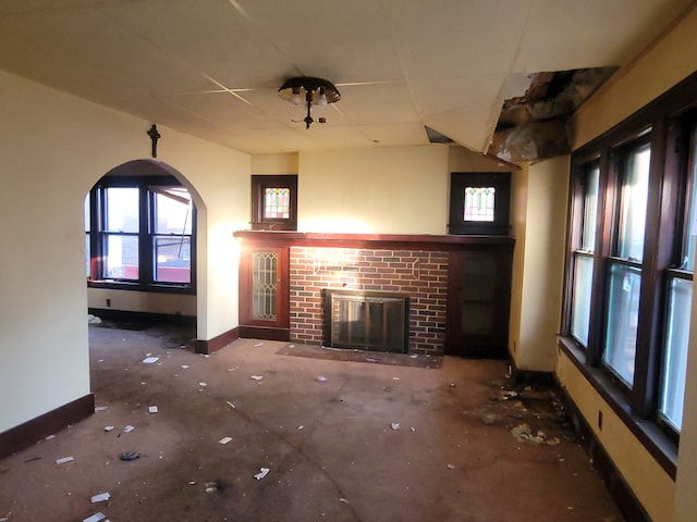 unfurnished living room featuring a brick fireplace