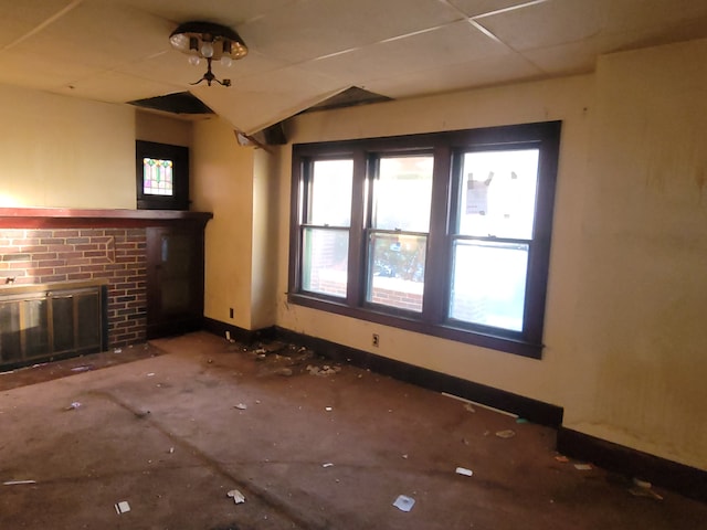 unfurnished living room featuring a healthy amount of sunlight and a brick fireplace