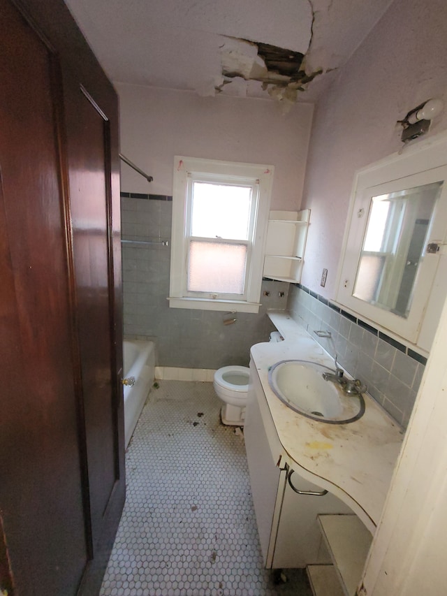 bathroom with decorative backsplash, vanity, tile walls, tile patterned flooring, and toilet