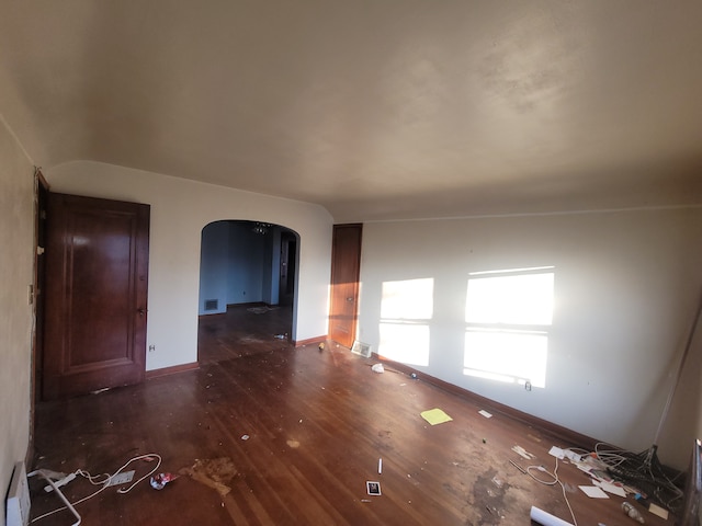 unfurnished living room featuring dark hardwood / wood-style flooring and a baseboard heating unit