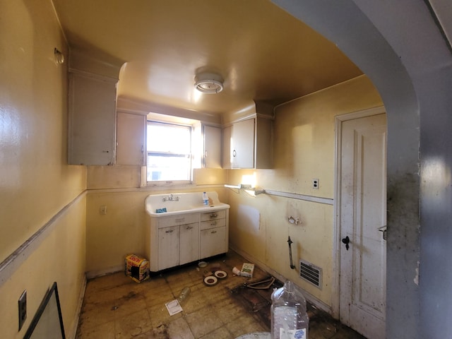 kitchen featuring white cabinetry and sink