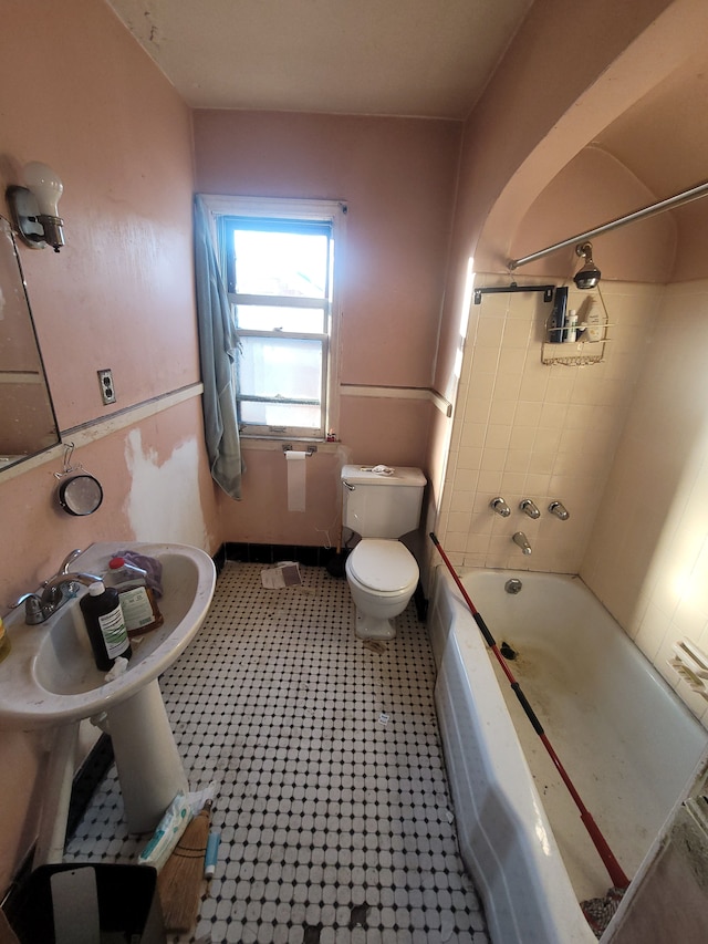 bathroom featuring toilet and tiled shower / bath