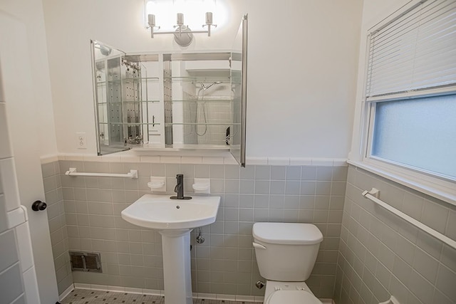 bathroom with tile patterned flooring, toilet, and tile walls