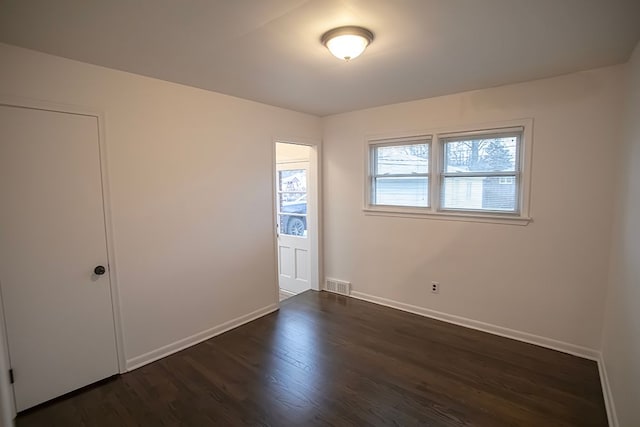 spare room featuring dark wood-type flooring