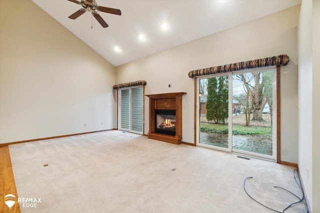 unfurnished living room with light colored carpet, high vaulted ceiling, and ceiling fan