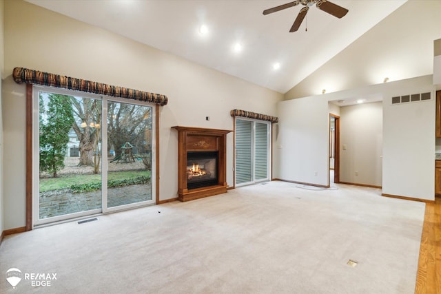 unfurnished living room with light colored carpet, high vaulted ceiling, and ceiling fan