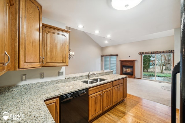 kitchen featuring dishwasher, lofted ceiling, light carpet, sink, and light stone countertops