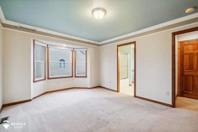 unfurnished bedroom with crown molding, light carpet, and connected bathroom